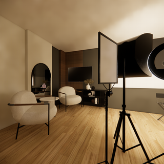 A modern photography studio with lounge chairs, a TV, and professional lighting equipment.